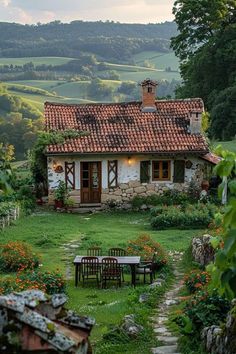 an old stone house in the middle of a lush green field