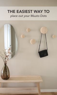 a wooden bench sitting under a mirror next to a vase with flowers in it and the words the easier way to place out your multi dots