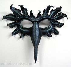 This wearable bird mask has been hand-molded from high quality vegetable tanned cow leather, from a template of my own design. It has been hand-painted with acrylic paint in a shimmery black with hints of blue and pewter, with metallic pewter highlights.The mask is painted both inside and out to seal and protect it. It is lightweight, flexible, and very comfortable to wear. It comes with two adjustable, removable ties attached. Great for use as part of a costume, or for display on the wall. The Raven Mask, Crow Mask, Bird Mask, S Drawing, Crow Bird, Bird Masks, Shape Templates, Hand Molding, Costume Mask