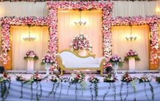 a wedding stage decorated with flowers and greenery