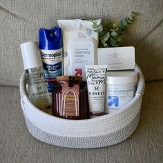 a basket filled with personal care items on a couch next to a plant and toiletries