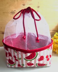 a red and white bag with watermelon designs on it sitting on a table