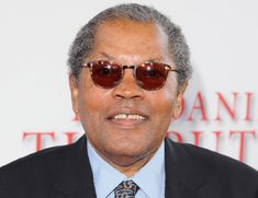 an older man wearing sunglasses and a suit