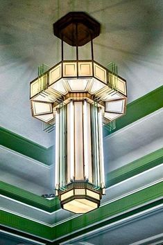 a chandelier hanging from the ceiling in a room with green and white walls