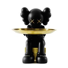 a black and gold figurine holding a plate with two ears on it's head