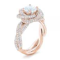 a rose gold engagement ring with an aqua blue topazte center surrounded by white diamonds