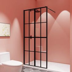 a bathroom with pink walls and a white toilet next to a walk in shower stall