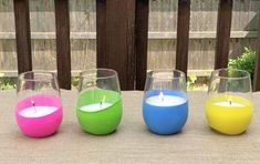 three different colored candles sitting on top of a table