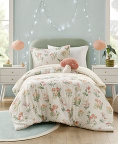 a bedroom with blue walls and white bedding has a pink stuffed animal on the pillow