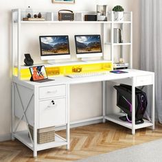 a white desk with two computer monitors and a yellow shelf above it on top of a hard wood floor