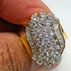 a man's hand holding a ring with diamonds on it and the band around his finger