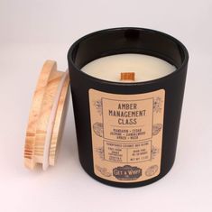 a black candle sitting next to a wooden lid