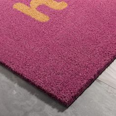 a pink rug with yellow letters on it