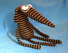 a stuffed animal that is sitting down on a blue surface with black and white stripes