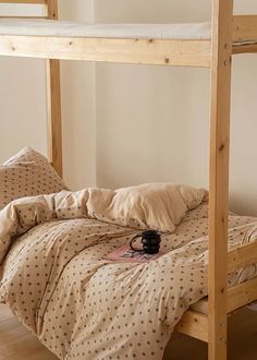 there is a coffee cup on the bottom bunk bed with polka dot sheets and pillows