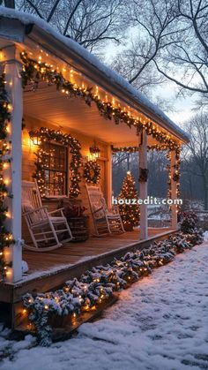 a porch covered in snow with christmas lights and rocking chairs on the front porch, all lit up