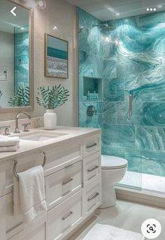 a bathroom with a glass shower door and marble counter tops, along with a white toilet