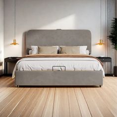 a large bed sitting on top of a wooden floor next to a plant in a room