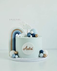 a white cake with blue, gold and white decorations on the top that says artis