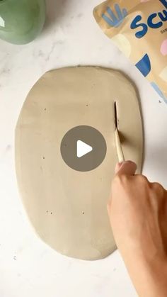 someone is using a knife to cut out the top of a doughnut on a table