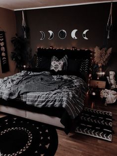 a bed room with a neatly made bed and several moon phases hanging on the wall