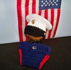 a crocheted hat and purse sitting on a table in front of an american flag