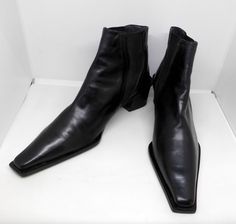 Offered for sale is this stunning pair of vintage Stuart Weitzman short black leather slip-on boots with a square toe and heel. The pair is pre-owned and in gently worn condition, and is marked a Size 8 1/2 AA. Stuart Weitzman is an American designer who had been designing shoes since the early 1960's under his father's label, Seymour Weitzman. In 1986 he launched his namesake brand and the majority of his collections have been produced in Elda, Spain, a tiny city known for its artisanal shoemak Classic High Heel Chelsea Boots For Formal Occasions, Classic Square Toe Chelsea Boots For Formal Occasions, Fitted Formal Chelsea Boots With Square Toe, Formal Fitted Chelsea Boots With Square Toe, Vintage Formal Boots Medium Width, Elegant Fitted Chelsea Boots With Square Toe, Evening Black Mid-calf Boots With Square Toe, Elegant Black Mid-calf Boots With Square Toe, Leather Boots With 4-inch Heel And Square Toe