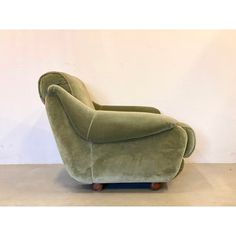 a green chair sitting in front of a white wall