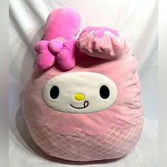 a pink stuffed animal sitting on top of a pillow