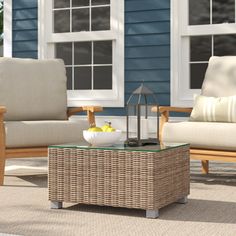 a wicker coffee table sitting on top of a rug