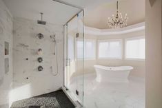 a bathroom with a tub, chandelier and shower