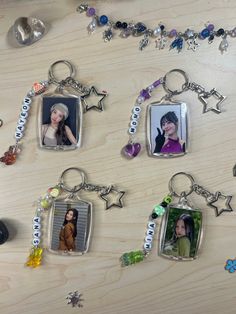 four different key chains with pictures and charms attached to them on a table next to other items