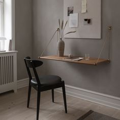 a table with a vase on it next to a radiator and a chair