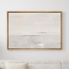 a living room with a white couch and large painting hanging on the wall above it