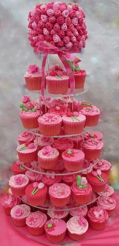 cupcakes are arranged in the shape of a tower with pink frosting on top