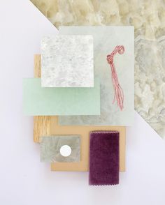 several pieces of art are displayed on a white surface with purple and green papers around them