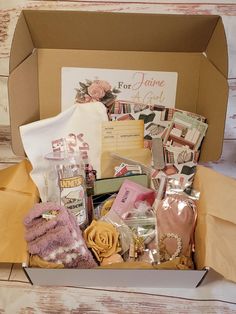 a box filled with lots of items sitting on top of a wooden floor