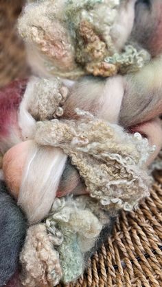 several skeins of wool sitting on top of each other in a wicker basket