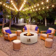 an outdoor fire pit surrounded by chairs and tables