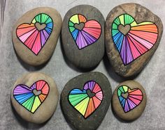 some rocks with hearts painted on them and one has a heart in the shape of a fan