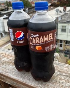 two bottles of pepsi soda sitting on top of a wooden table next to each other