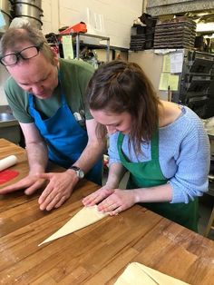 a man and woman are working together in the kitchen