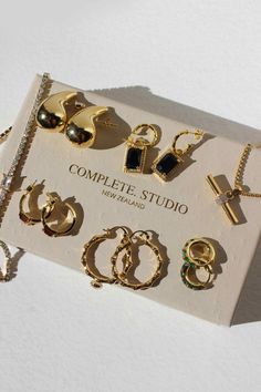 an assortment of jewelry is displayed on a white surface with the words complete studio written below it