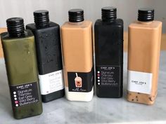 five different types of juice bottles lined up on a counter