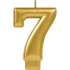 a gold number seven candle on a white background