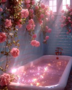 a bathtub filled with pink flowers next to a window covered in sunlight and water