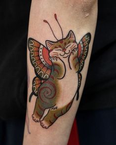 a cat with a butterfly tattoo on its arm