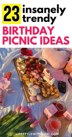 there is a birthday picnic with pink flowers and treats on the table, along with other items