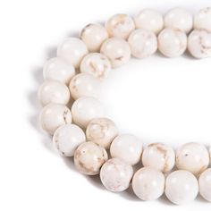 two strands of white marble beads on a white background