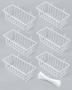 six white wire baskets sitting on top of a table